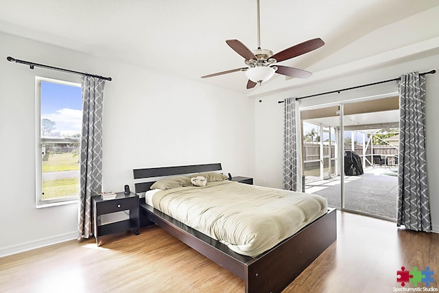 bedroom with a ceiling fan, access to outside, wood finished floors, baseboards, and vaulted ceiling