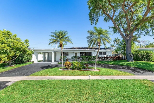 single story home featuring aphalt driveway, a carport, a front lawn, and stucco siding