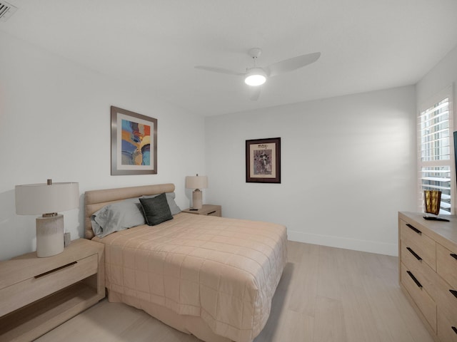 bedroom featuring baseboards, light wood finished floors, and ceiling fan