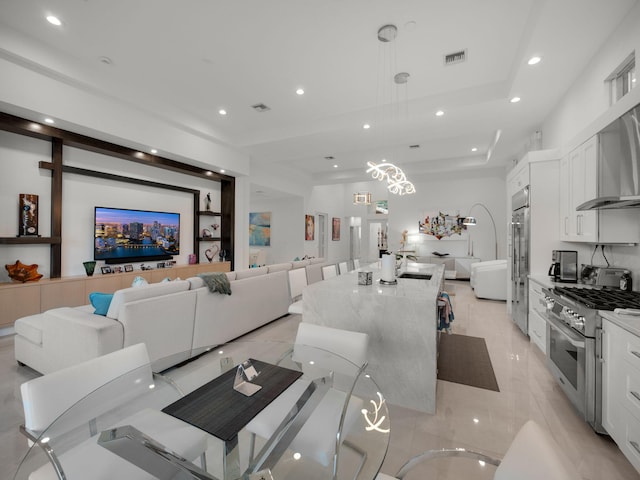 living room with visible vents, recessed lighting, and a raised ceiling