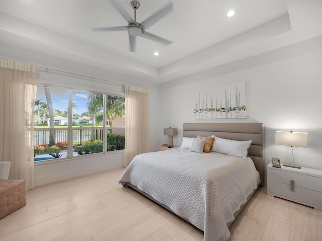 bedroom featuring recessed lighting, a raised ceiling, ceiling fan, and wood finished floors