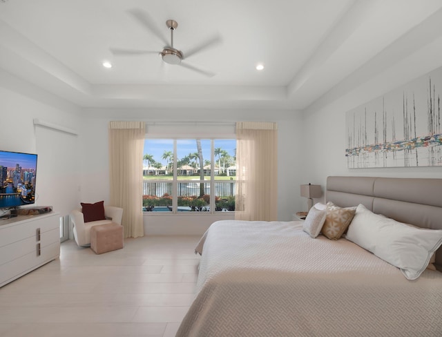 bedroom featuring recessed lighting, a raised ceiling, and a ceiling fan