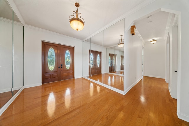 entryway with french doors, crown molding, baseboards, and wood finished floors