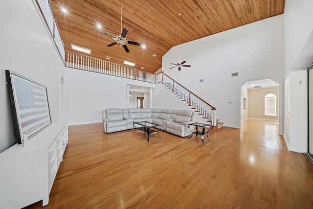 living room with wood finished floors, arched walkways, high vaulted ceiling, and wooden ceiling