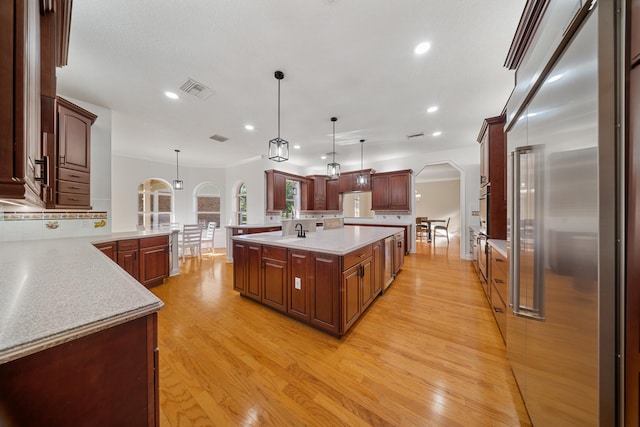 kitchen with visible vents, arched walkways, light countertops, appliances with stainless steel finishes, and backsplash