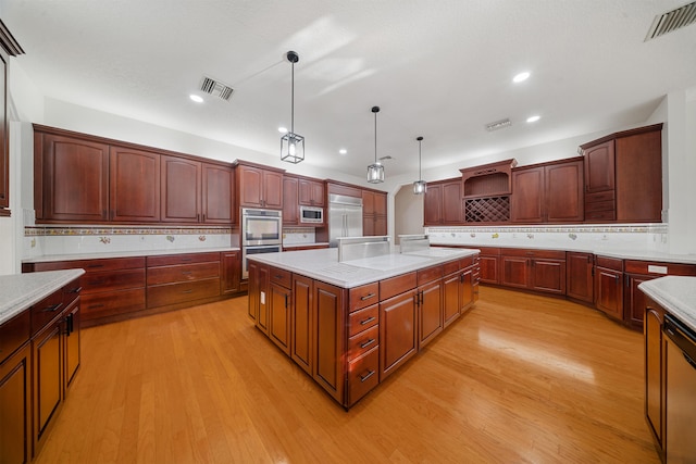 kitchen featuring visible vents, a kitchen island, built in appliances, light wood-style flooring, and open shelves