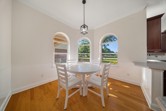 unfurnished dining area with visible vents, light wood-style floors, wainscoting, and crown molding