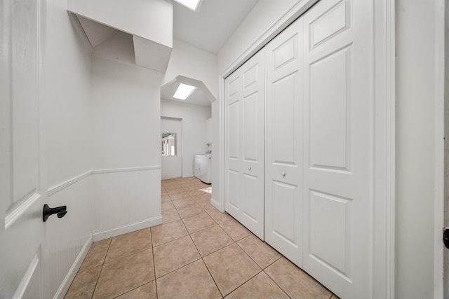 hallway featuring light tile patterned floors and baseboards