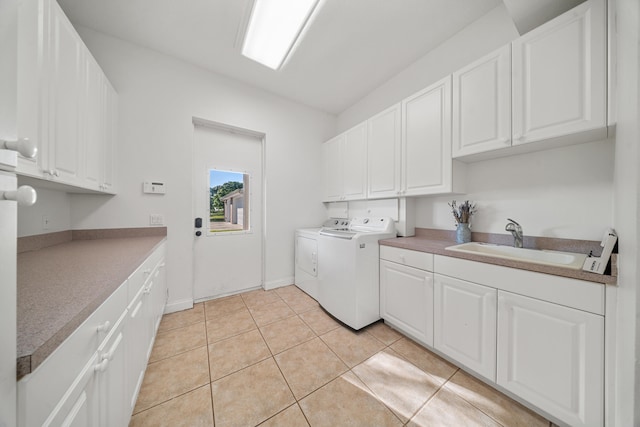 laundry room with a sink, cabinet space, washing machine and dryer, and light tile patterned floors