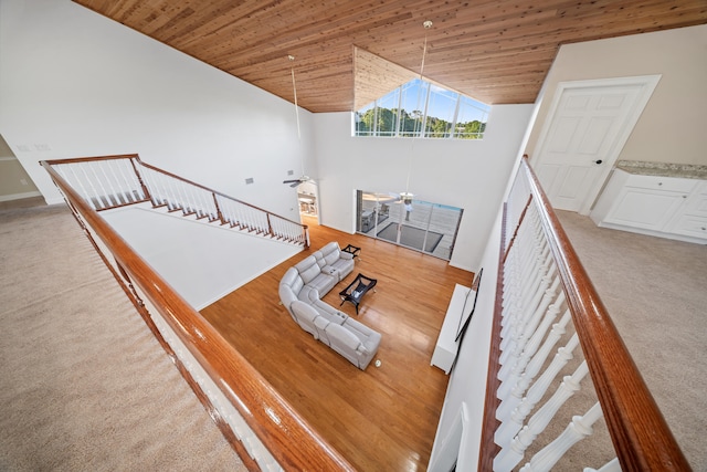 unfurnished living room featuring carpet floors, high vaulted ceiling, wooden ceiling, and a ceiling fan