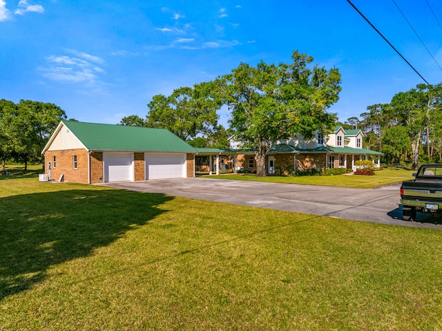 view of front facade with a front yard, a garage, brick siding, and driveway