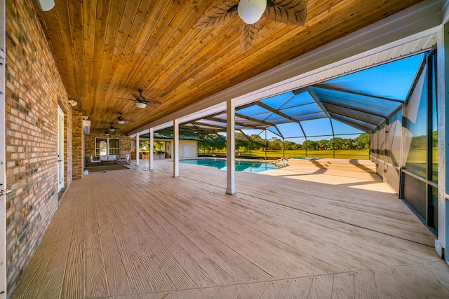 wooden terrace with a lanai, an outdoor pool, and ceiling fan