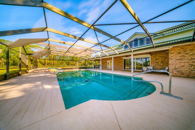 pool at dusk featuring a patio, an outdoor pool, a lanai, and ceiling fan