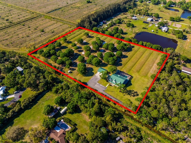 birds eye view of property with a water view and a rural view