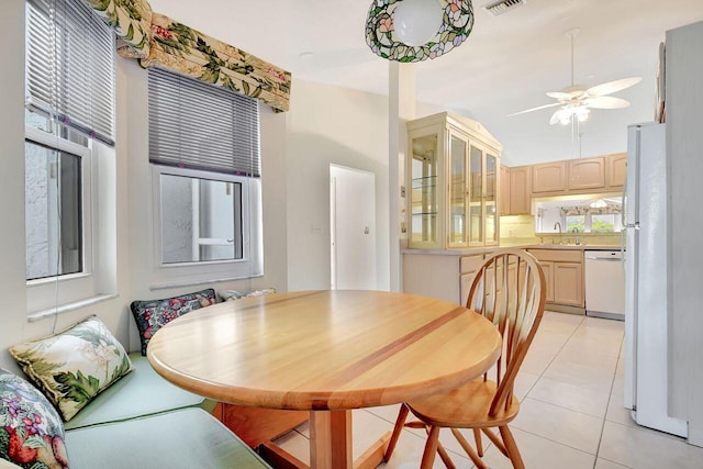 dining room featuring lofted ceiling, light tile patterned floors, a ceiling fan, and visible vents