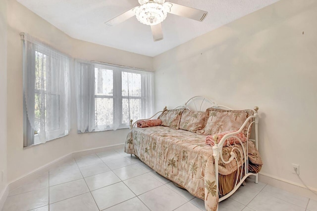 bedroom with light tile patterned floors, baseboards, and ceiling fan