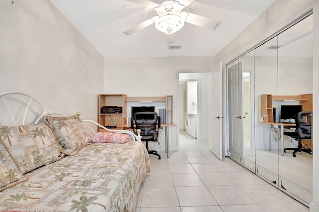 bedroom with washer / dryer, light tile patterned floors, a ceiling fan, and visible vents