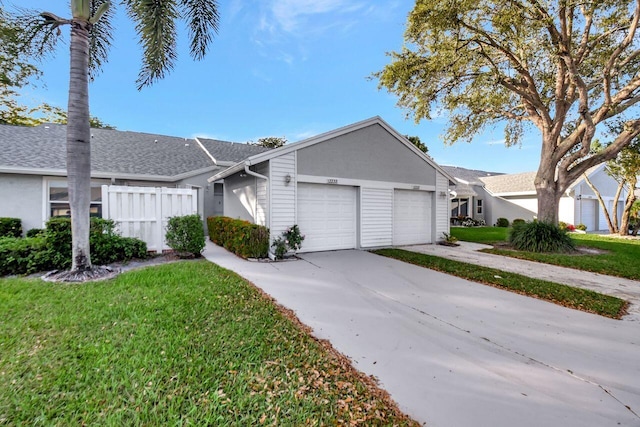 single story home featuring a front lawn, fence, roof with shingles, concrete driveway, and a garage