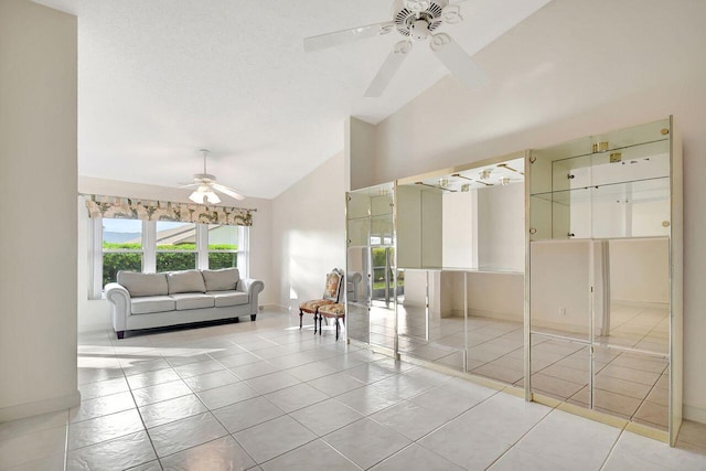 interior space with baseboards, high vaulted ceiling, ceiling fan, and tile patterned flooring