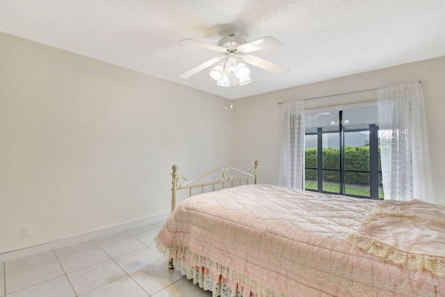 bedroom featuring light tile patterned floors, baseboards, a textured ceiling, and ceiling fan