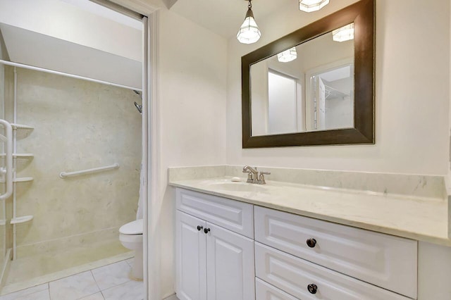 bathroom featuring vanity, tile patterned floors, toilet, and a stall shower