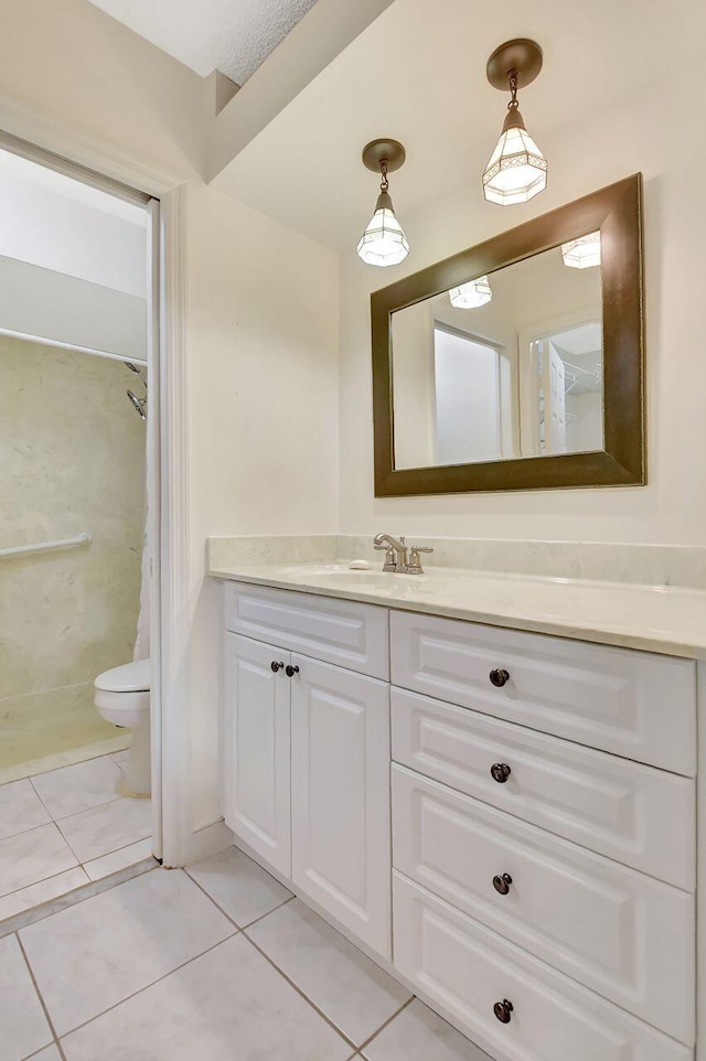 bathroom featuring tile patterned floors, a shower, toilet, and vanity