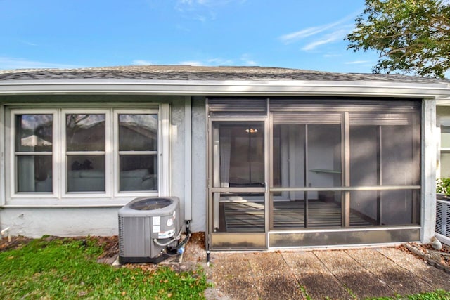 exterior space with central AC and a shingled roof