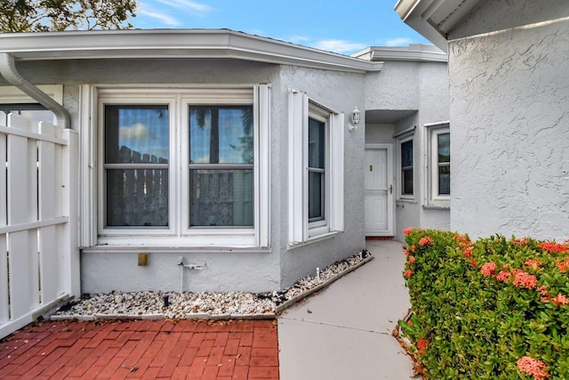 doorway to property featuring stucco siding