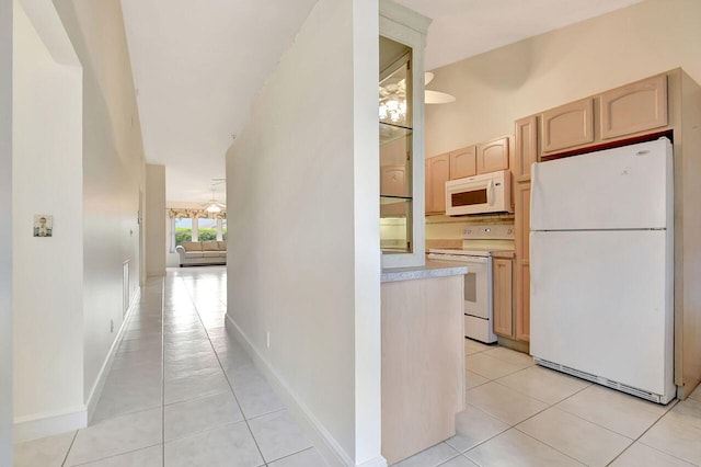 kitchen featuring light brown cabinetry, white appliances, light countertops, light tile patterned floors, and baseboards