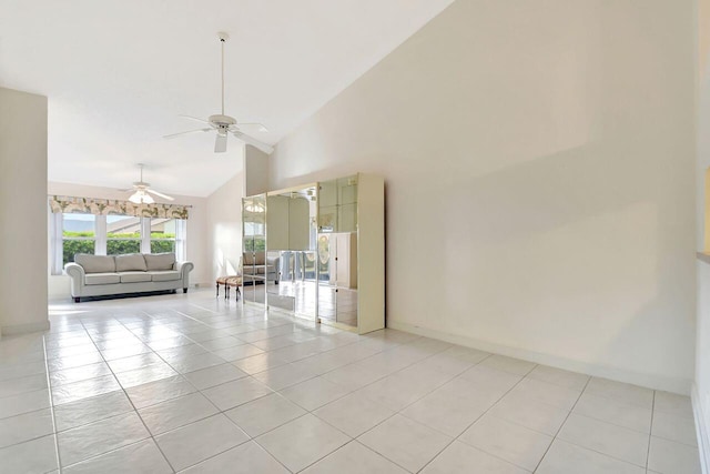 unfurnished living room featuring light tile patterned floors, baseboards, high vaulted ceiling, and ceiling fan