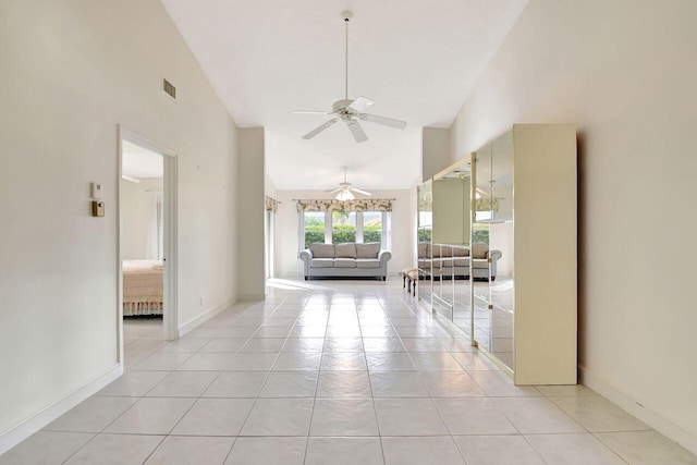 unfurnished living room with light tile patterned floors, visible vents, and high vaulted ceiling