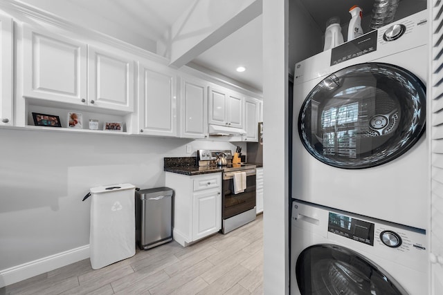 laundry area featuring stacked washer and dryer, recessed lighting, light wood-style floors, and baseboards