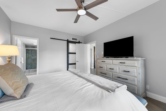 bedroom with visible vents, baseboards, a barn door, wood finished floors, and a ceiling fan