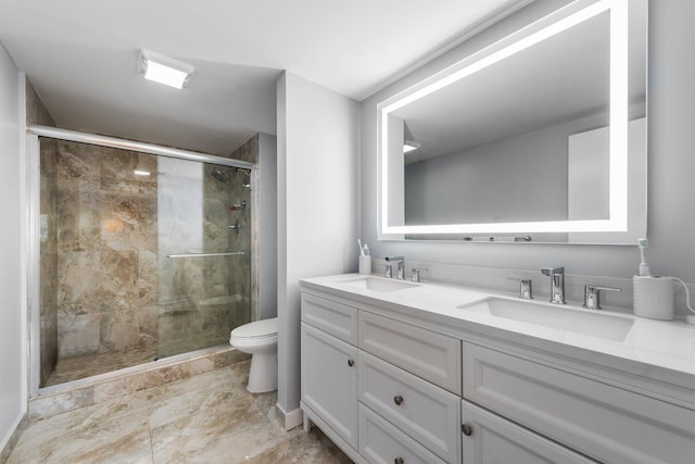 bathroom with a shower stall, toilet, double vanity, and a sink