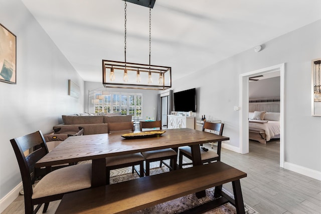 dining area featuring light wood-style flooring and baseboards