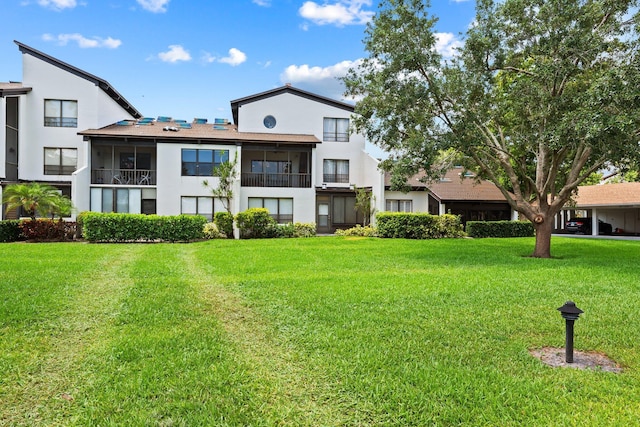 back of property featuring stucco siding and a yard