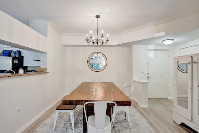 dining area featuring light wood-type flooring, baseboards, ornamental molding, and a chandelier