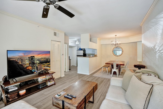 living room featuring ornamental molding, ceiling fan with notable chandelier, visible vents, and wood tiled floor