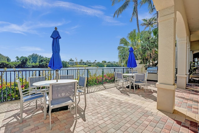 view of patio with outdoor dining area and a water view