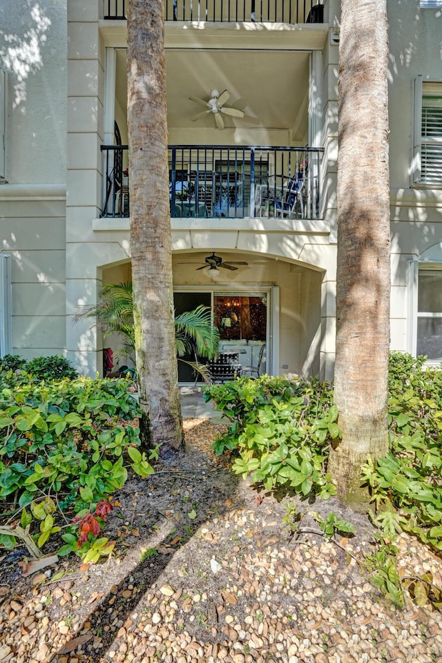 entrance to property with a balcony and a ceiling fan