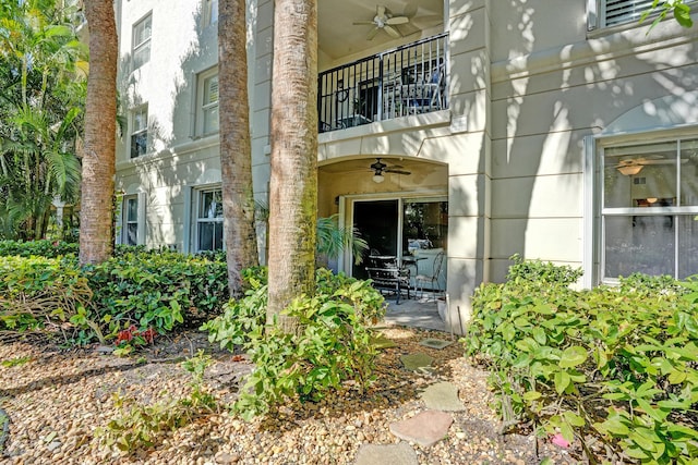 entrance to property with a balcony and ceiling fan