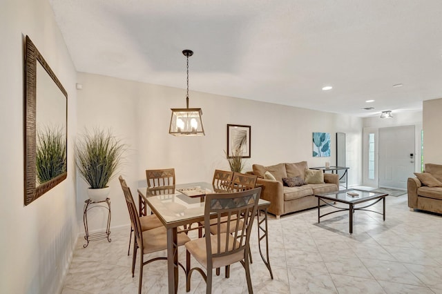 dining area featuring a chandelier, recessed lighting, and marble finish floor