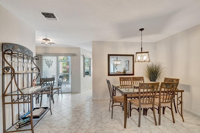 dining room featuring a notable chandelier, visible vents, and baseboards