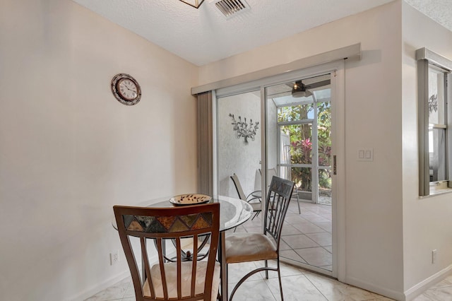 dining space with baseboards, visible vents, and a textured ceiling