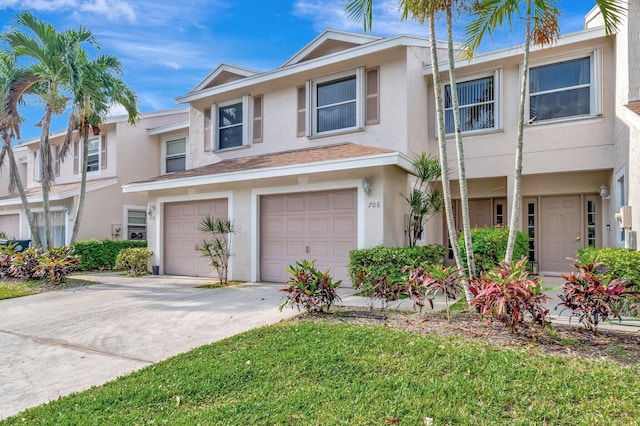 multi unit property featuring stucco siding, concrete driveway, and a garage