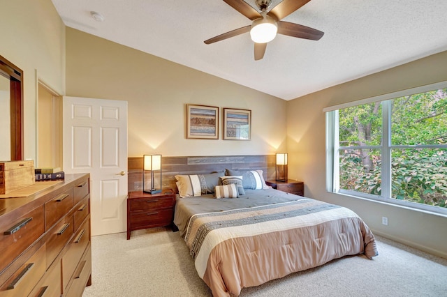 bedroom featuring light carpet, a textured ceiling, ceiling fan, and vaulted ceiling