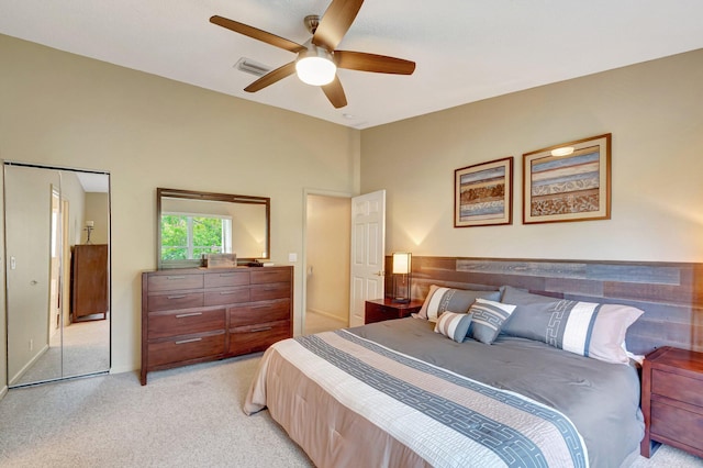 bedroom with light carpet, visible vents, and a ceiling fan