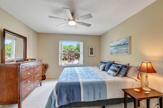 bedroom with baseboards, carpet floors, a textured ceiling, and ceiling fan