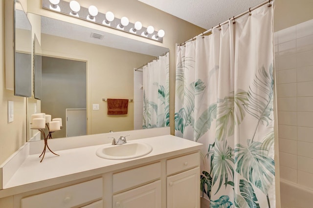 bathroom featuring visible vents, a textured ceiling, and vanity