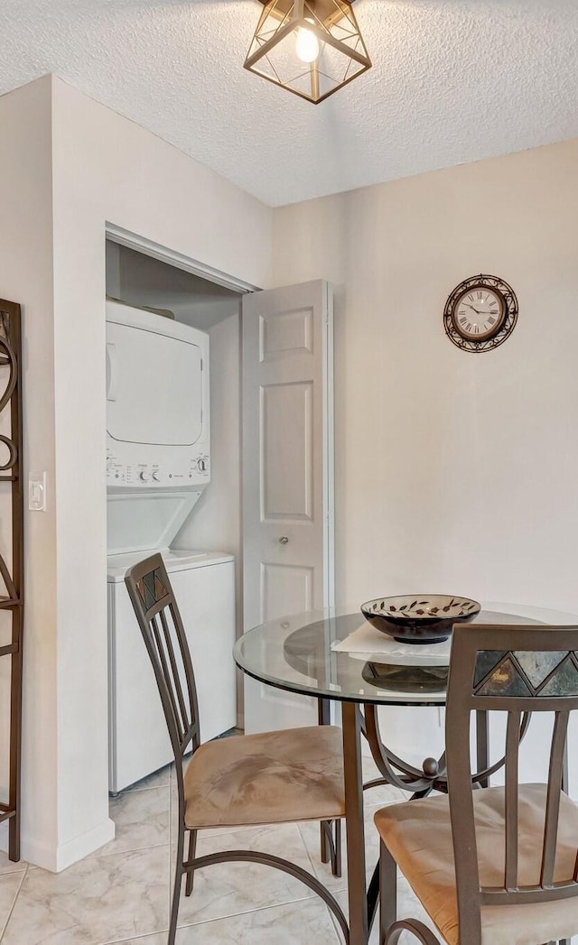 dining area featuring a textured ceiling and stacked washer / drying machine